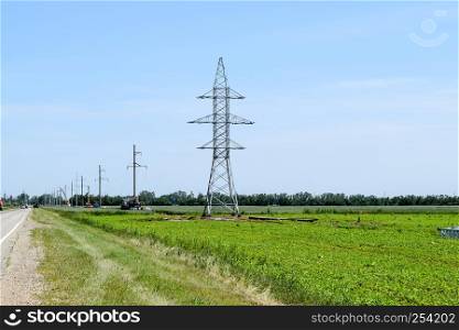 Transmission tower on a background field of soybeans.. Transmission tower on a background field of soybeans