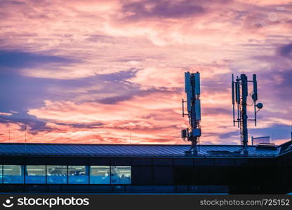 Transmitter antennas in the evening. Orange sky and clouds.