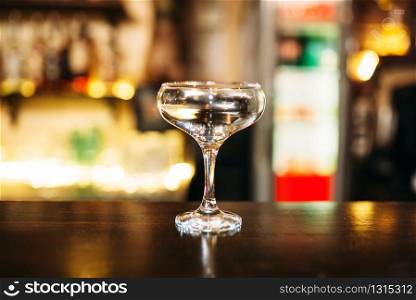 Transparent beverage in glass on wooden bar counter
