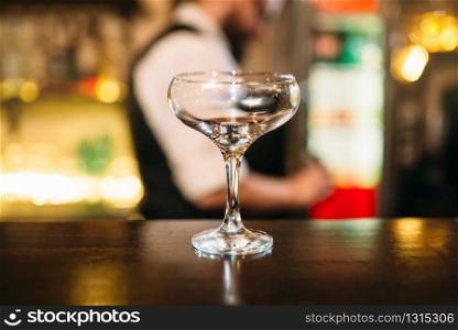 Transparent beverage in glass on wooden bar counter. Transparent beverage in glass on bar counter