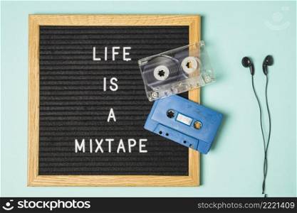 transparent blue cassette tape message board with earphone turquoise backdrop