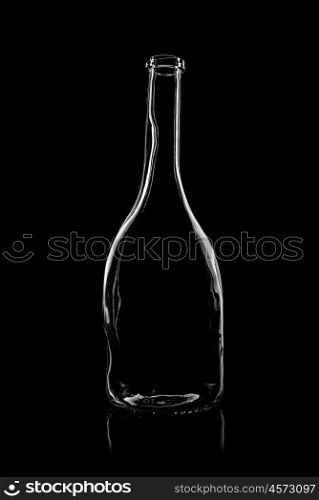 transparent bottle of brandy on a black background with reflection
