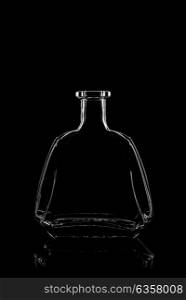 transparent bottle of brandy on a black background with reflection