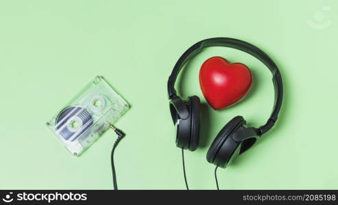 transparent cassette tape connected with headphone around red heart