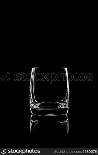 transparent glass for brandy or cognac on black background with reflection