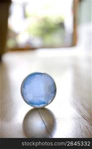 Transparent glass globe on a wooden floor