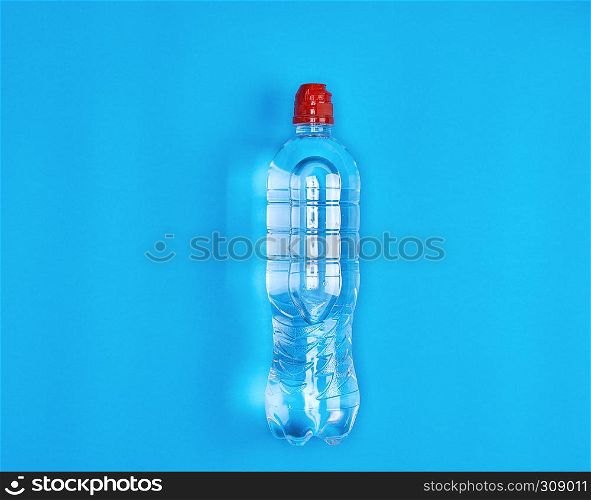 transparent plastic bottle with fresh water on a blue background, copy space