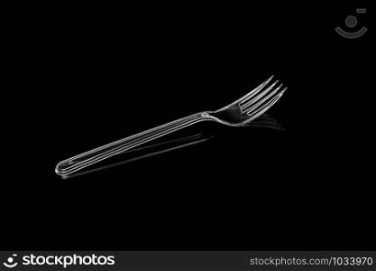 Transparent plastic fork isolated on black background. With clipping path