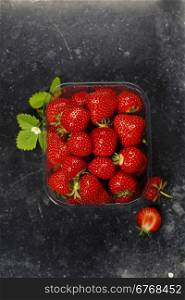 Transparent plastic tray with freshly picked strawberries