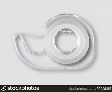 Transparent scotch tape dispenser isolated on grey background. Scotch tape dispenser isolated on grey background. Scotch tape dispenser isolated on grey background
