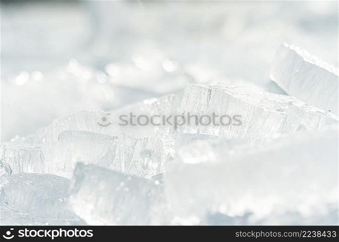 Transparent shining clear ice icicles close-up sparkling on frozen wild lake shore in sunset light. Cold winter nature background. Stacks of drift ice piled up against the dutch coast with crystal clear sunlight