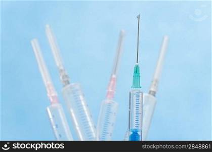 Transparent syringe with liquid drop falling from needle