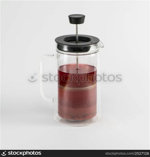 transparent teapot with fruit drink on white background, isolated. piston teapot. tea drink on white background