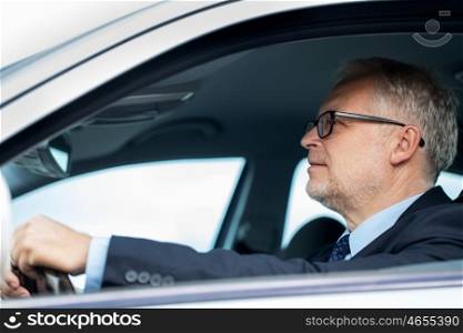 transport, business trip and people concept - happy senior businessman driving car