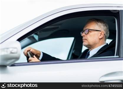 transport, business trip and people concept - happy senior businessman driving car
