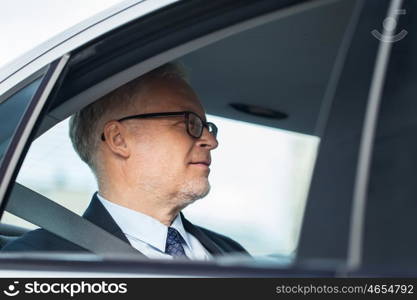 transport, business trip and people concept - senior businessman driving on car back seat