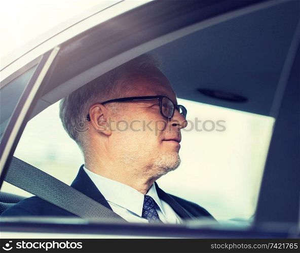transport, business trip and people concept - senior businessman driving on car back seat. senior businessman driving on car back seat
