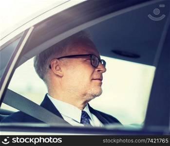 transport, business trip and people concept - senior businessman driving on car back seat. senior businessman driving on car back seat