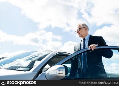 transport, business trip and people concept - senior businessman getting into car