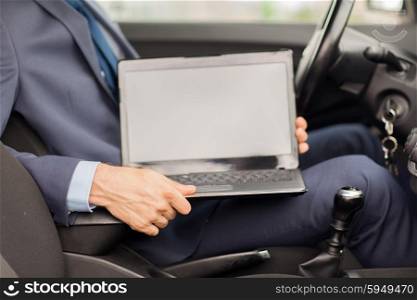 transport, business trip, destination and people concept - close up of young man with laptop computer blank screen sitting in car