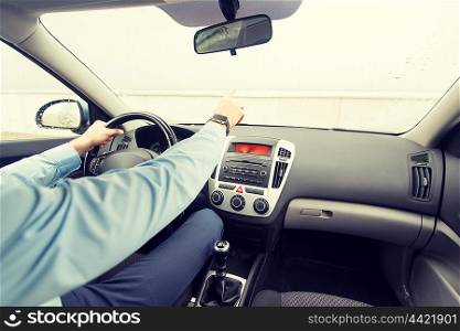 transport, business trip, direction and people concept - close up of young man driving car and pointing finger to something