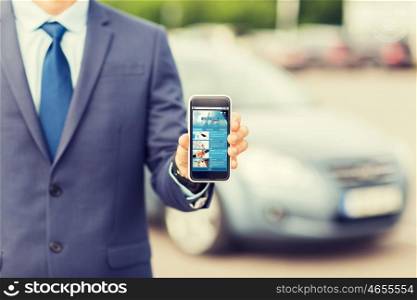 transport, business trip, mass media, technology and people concept - close up of man showing internet news page smartphone screen on car parking
