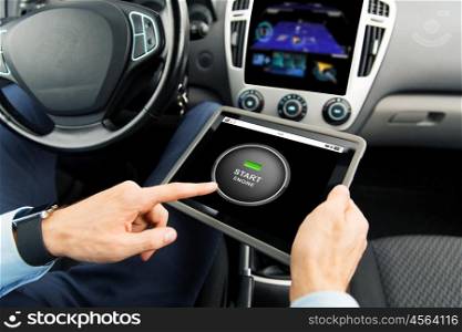 transport, business trip, modern technology and people concept - close up of male hands holding tablet pc computer with start engine button on screen in car