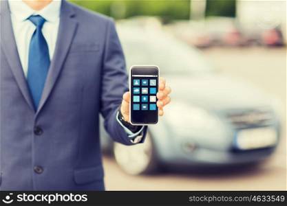 transport, business trip, multimedia, technology and people concept - close up of man showing menu icons smartphone screen on car parking