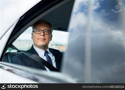 transport, business trip, safety and people concept - senior businessman driving on car back seat