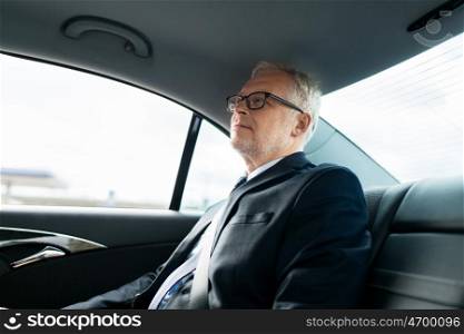transport, business trip, safety and people concept - senior businessman driving on car back seat