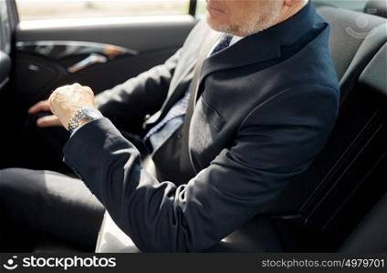 transport, business trip, safety and people concept - senior businessman driving on car back seat. senior businessman driving on car back seat