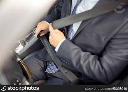transport, business trip, safety and people concept - senior businessman fastening seat belt before driving car. senior businessman fastening car seat belt