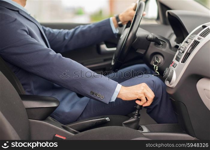 transport, business trip, speed, destination and people concept - close up of young man in suit driving car