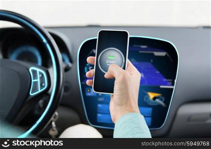 transport, business trip, technology and people concept - close up of male hands with start engine button on smart phone screen in car