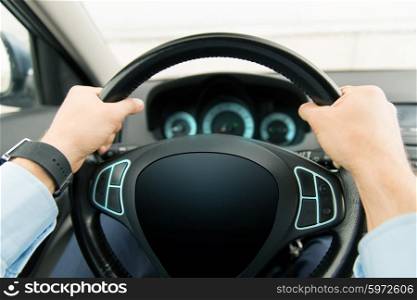 transport, business trip, technology and people concept - close up of male hands holding car wheel and driving with black blank board computer screen