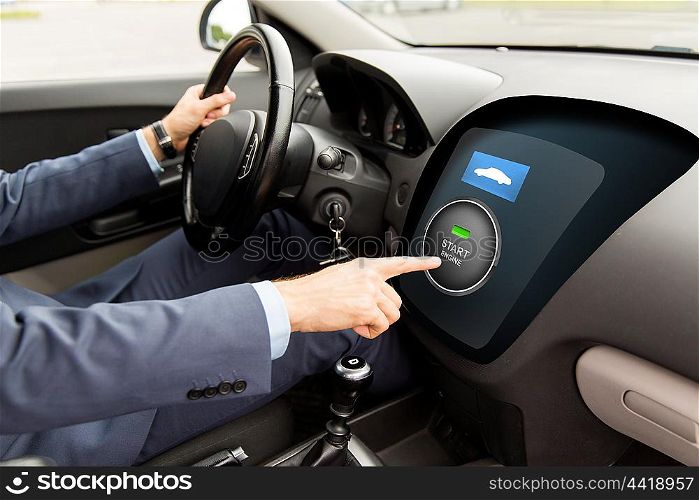 transport, business trip, technology and people concept - close up of man driving car and pushing start engine button on board computer