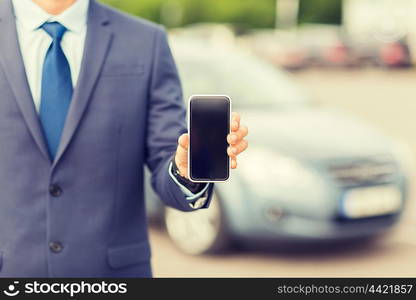 transport, business trip, technology and people concept - close up of man showing smartphone blank screen on car parking