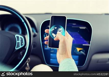 transport, business trip, technology and people concept - close up of young man hand with globe on smartphone screen driving car
