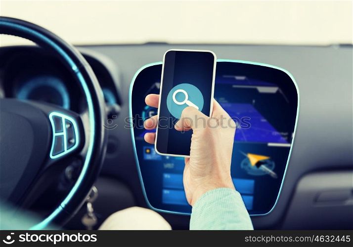 transport, business trip, technology and people concept - close up of young man hand driving car and holding smartphone with lens icon on screen