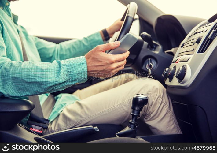 transport, business trip, technology and people concept - close up of young man with smartphone driving car