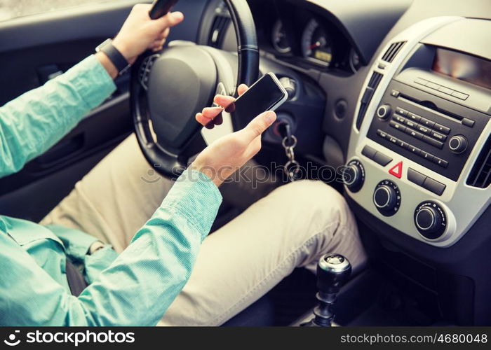 transport, business trip, technology and people concept - close up of young man with smartphone driving car