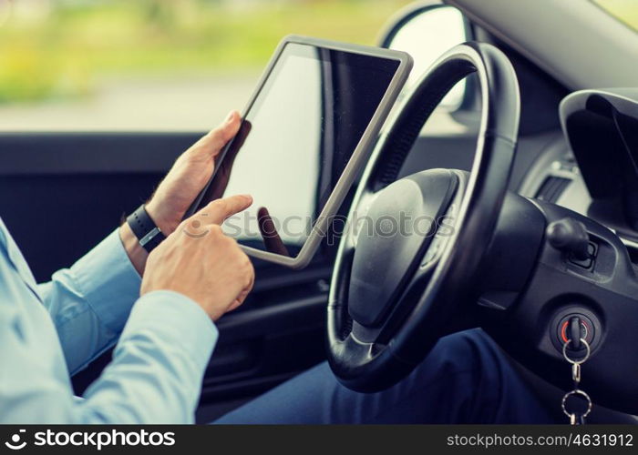 transport, business trip, technology and people concept -close up of young man with tablet pc computer driving car