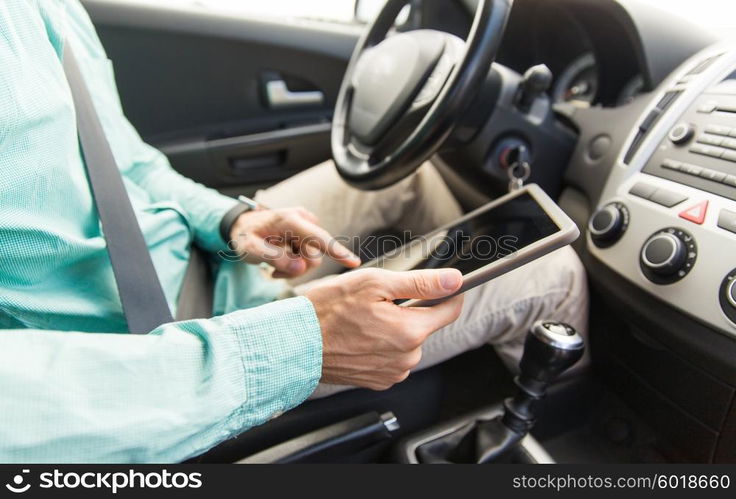 transport, business trip, technology and people concept -close up of young man with tablet pc computer driving car