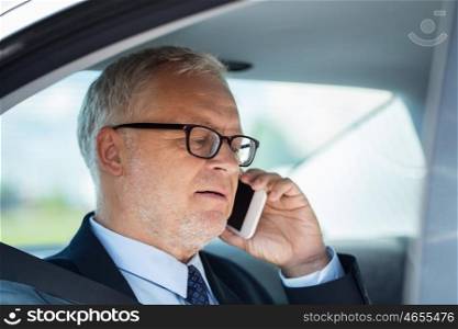 transport, business trip, technology and people concept - senior businessman calling on smartphone and driving on car back seat