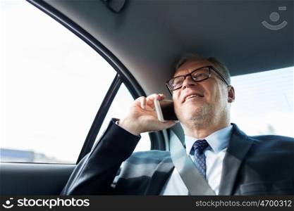 transport, business trip, technology and people concept - senior businessman calling on smartphone and driving on car back seat