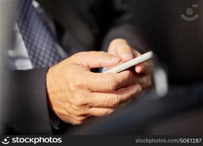 transport, business trip, technology and people concept - senior businessman texting on smartphone and driving on car back seat. senior businessman texting on smartphone in car
