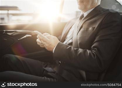 transport, business trip, technology and people concept - senior businessman texting on smartphone and driving on car back seat. senior businessman texting on smartphone in car. senior businessman texting on smartphone in car