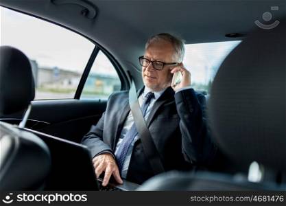 transport, business trip, technology and people concept - senior businessman with laptop computer calling on smartphone and driving on car back seat