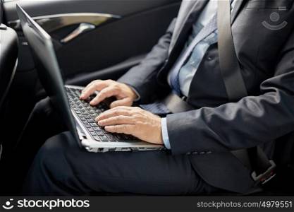 transport, business trip, technology and people concept - senior businessman with laptop computer driving on car back seat. senior businessman with laptop driving in car