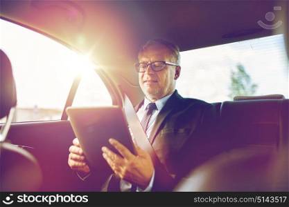 transport, business trip, technology and people concept - senior businessman with tablet pc computer driving on car back seat. senior businessman with tablet pc driving in car